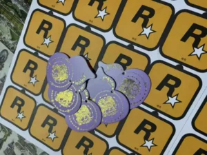 Purple logo-shaped paper air freshener tags displayed on printed production sheets
