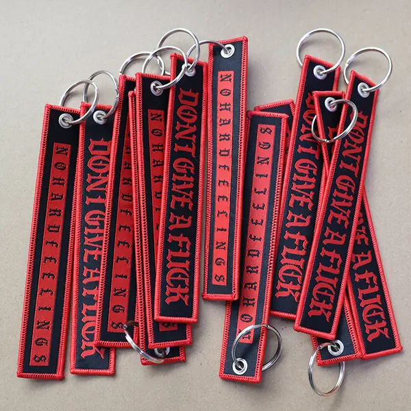 Red and black embroidered fabric keychains with metal eyelets and split rings