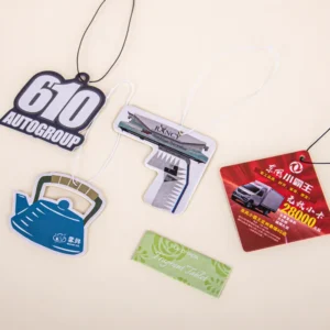 Assorted custom-shaped printed air freshener tags with black and white hanging cords