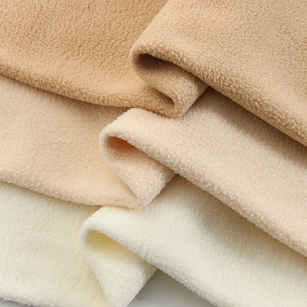 Folded beige and cream fabric with a soft fleece texture