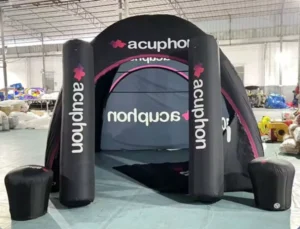 Black acuphon-branded inflatable event tent with large printed entry columns inside a workshop