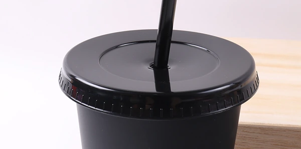 Close-up of a black tumbler with a fitted lid and upright straw