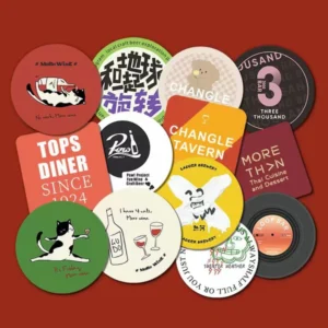 Assorted round and square printed coasters featuring colorful bar, restaurant and brewery artwork