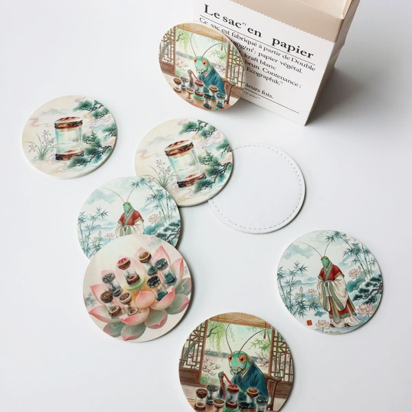 Round printed coasters featuring detailed illustrated scenes arranged beside a gift box