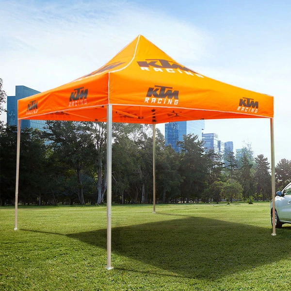 Orange KTM-branded pop up canopy with open sides displayed on grass outdoors