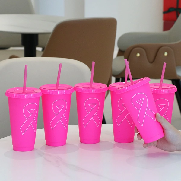 Bright pink tumblers with white ribbon graphics, matching lids and straws