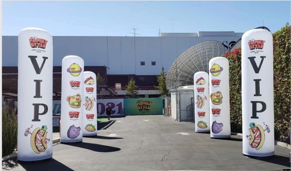White inflatable columns with VIP lettering and food graphics at an outdoor entrance